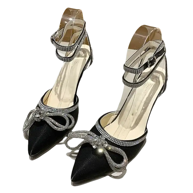 Black high-heeled shoes with rhinestone bows and ankle straps.