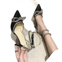 Black stiletto heels with rhinestone bows and clear straps.