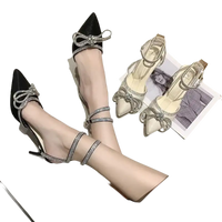 Elegant high-heeled shoes with rhinestone bows and ankle straps.