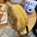 Tan plush bear pouch with yellow zipper.