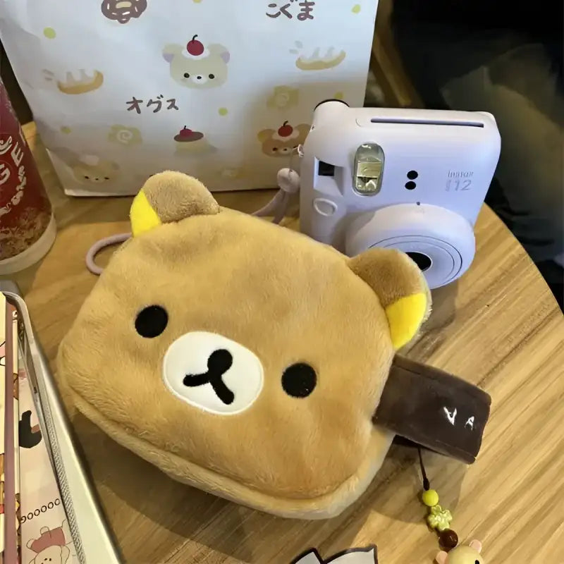 Tan plush bear-shaped pouch.