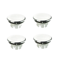 Four white and chrome sink hole covers.