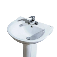 White pedestal sink with chrome faucet.