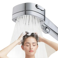 Chrome shower head with water flowing.