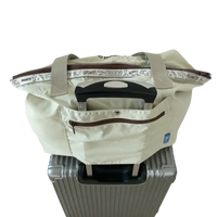 Beige tote bag on suitcase.