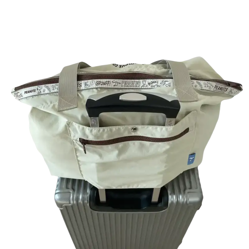 Beige tote bag on suitcase.