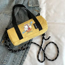Yellow cylindrical handbag with cartoon astronaut.