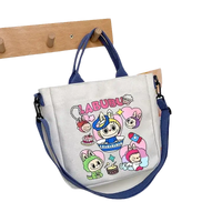 Cartoon-decorated canvas tote bag with blue straps.