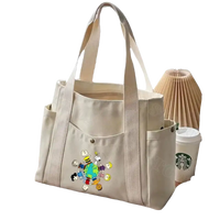 Beige canvas tote bag with cartoon characters.