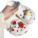 White Crocs with strawberry and ice cream charms.
