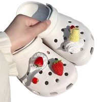 White Crocs with strawberry and ice cream charms.