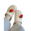 White Crocs with strawberry charms.