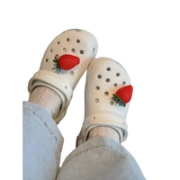 White Crocs with strawberry charms.