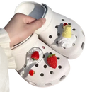 White Crocs with strawberry and ice cream charms.