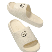 Cream-colored bear-themed slide sandals.