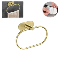 Gold-colored oval towel ring with adhesive mount.