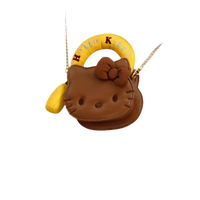 Brown Hello Kitty purse with yellow handle.
