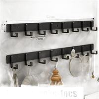 Black wall-mounted coat rack with eight hooks.