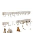 White wall-mounted coat rack with eight hooks.
