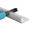 White adhesive-backed plastic strip being cut.