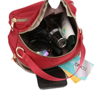 Red nylon handbag with contents.