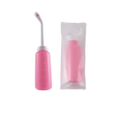 Pink portable bidet with angled nozzle and packaging.