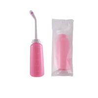 Pink portable bidet with angled nozzle and packaging.