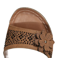 Brown sandal with flower embellishment.