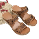 Tan wedge sandals with floral embellishments.