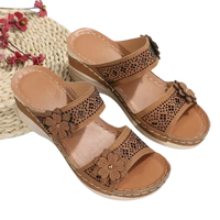 Tan wedge sandals with floral embellishments.