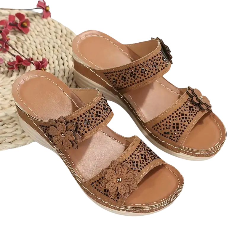 Tan wedge sandals with floral embellishments.
