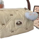 Quilted cream-colored handbag with Hello Kitty donut patch and blue gingham heart charm.
