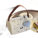 Quilted cream-colored handbag with brown handle and heart-shaped charm.