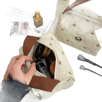 Quilted cosmetic bag with bow pattern.