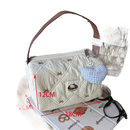 Quilted handbag with brown handle and heart charm.