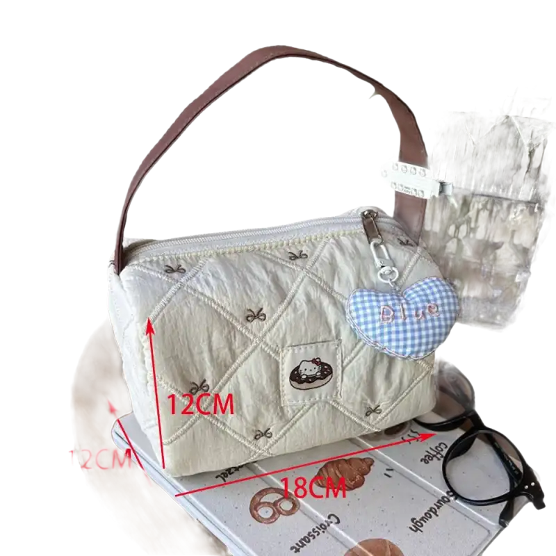 Quilted handbag with brown handle and heart charm.