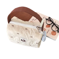 Quilted handbag with brown handle.