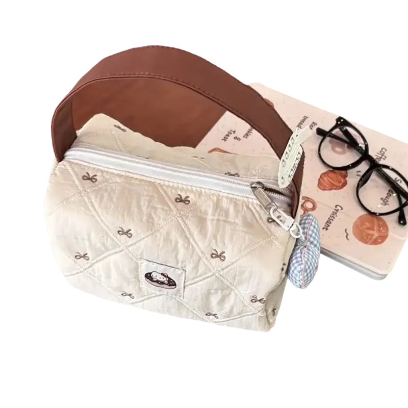 Quilted handbag with brown handle.