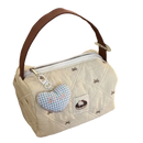 Quilted cream-colored handbag with brown handle and heart-shaped charm.