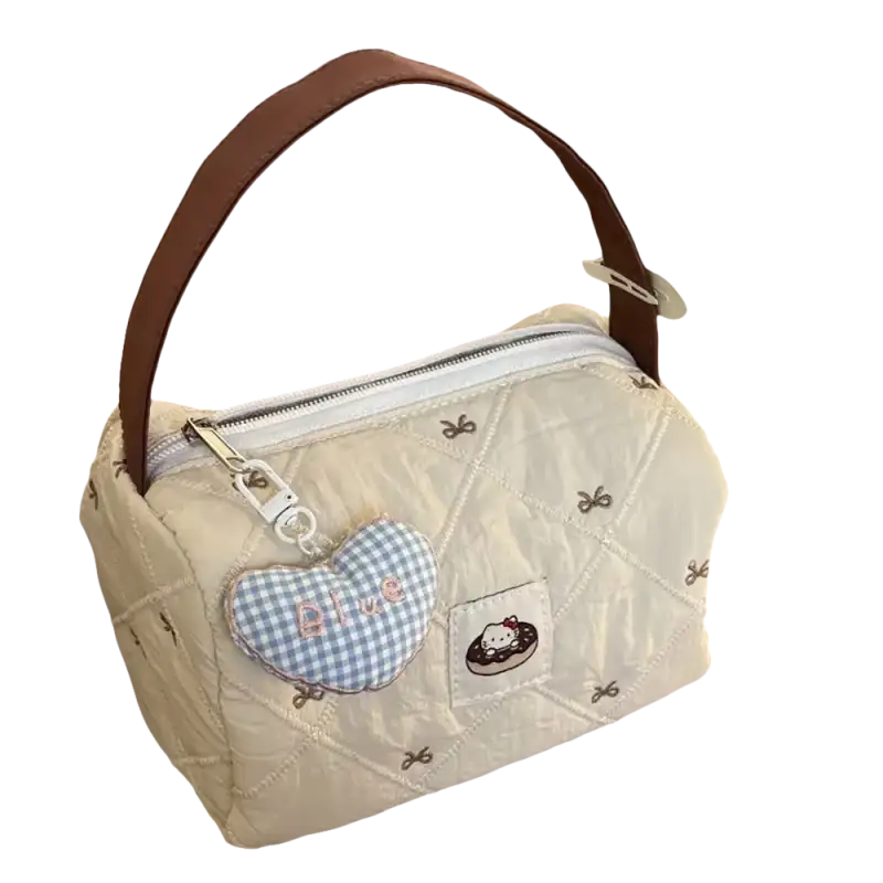 Quilted cream-colored handbag with brown handle and heart-shaped charm.