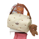 Quilted cream-colored handbag with brown handle and dog keychain.