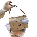 Quilted beige handbag with heart charm.