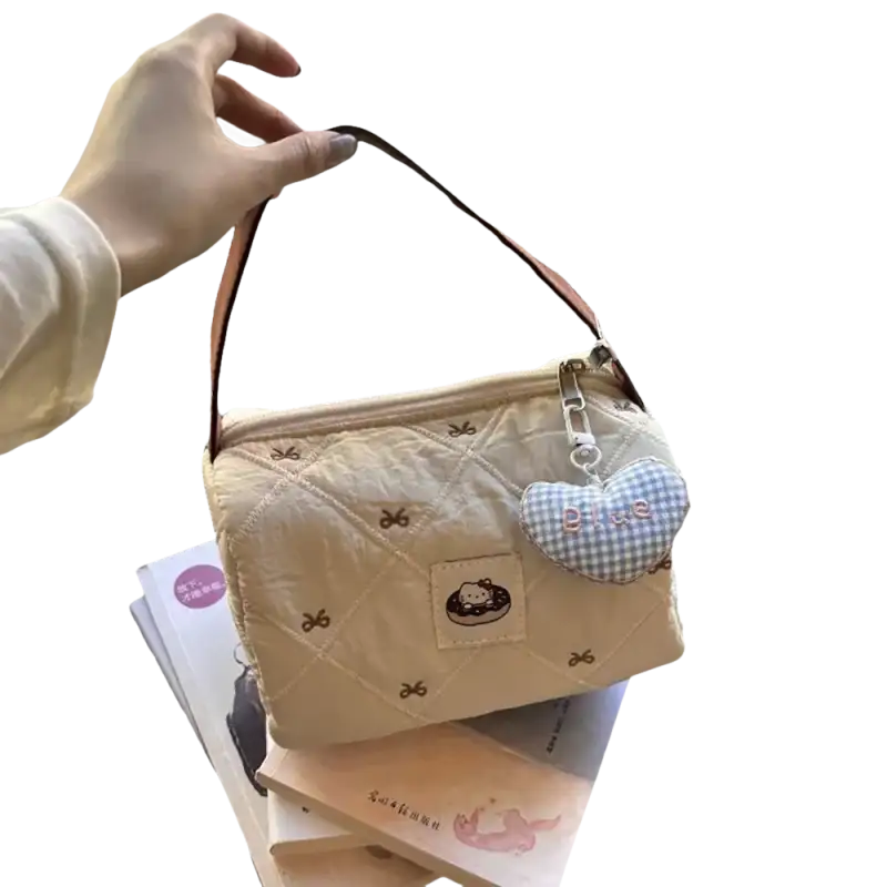 Quilted beige handbag with heart charm.