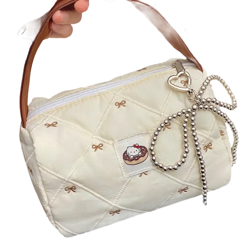 Quilted cream-colored handbag with brown handle and beaded bow.