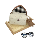 Cream-colored quilted handbag with bow pattern.