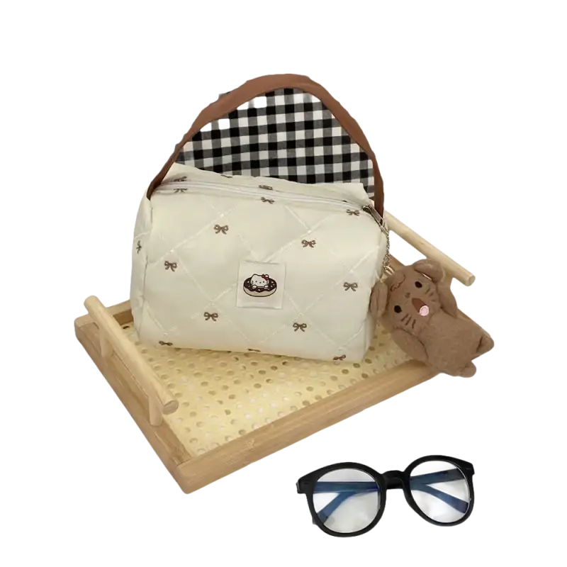 Cream-colored quilted handbag with bow pattern.