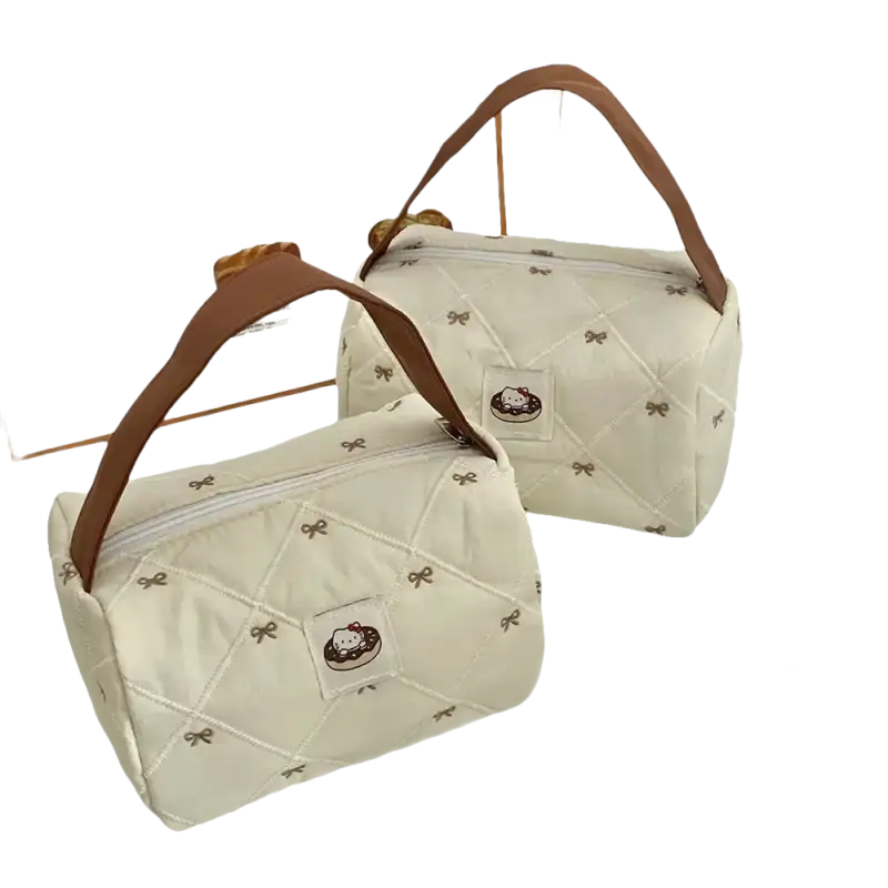 Two quilted, cream-colored handbags with brown handles.