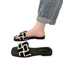 Black and white woven slide sandals.