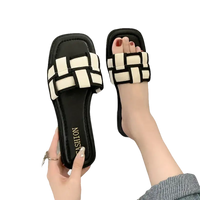 Black and white woven slide sandals.