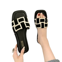 Black and white woven slide sandals.
